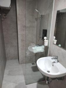 a bathroom with a sink and a glass shower at Serene Studio Pollux Batam Center - High Floor Sea View in Batam Center