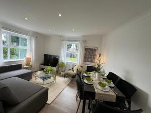 sala de estar con sofá, mesa y sillas en Coocos Den, en Hillingdon