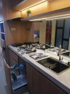 a kitchen counter with a sink and a mirror at Serene Studio Pollux Batam Center - High Floor Sea View in Batam Center