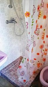 La salle de bains est pourvue d'un rideau de douche et de fleurs. dans l'établissement 2 bedrooms apartement with enclosed garden and wifi at Tortora Marina, à Praia a Mare