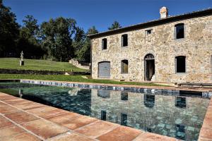 ein Steinhaus mit einem Pool davor in der Unterkunft Tenuta San Galgano in Monticiano