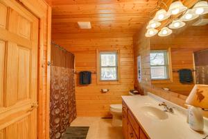 a bathroom with a sink and a toilet in a log cabin at Private Lakefront Emily Home with Yard and Fire Pit! in Emily +34 photos