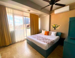 a bedroom with a bed and a large window at "5th Av" Sol del Caribe Apart Hotel in Playa del Carmen