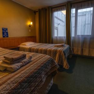 蓬塔阿雷納斯的住宿－Hotel Condor de Plata，酒店客房设有两张床和窗户。