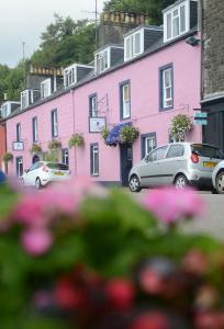 
a car parked on the side of a street next to a building at The Tobermory Hotel in Tobermory
