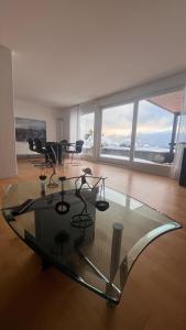 una mesa de cristal en una sala de estar con sillas y mesas. en Swiss Paradise Weggis en Weggis