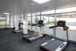 a gym with several tread machines in a building at Silk Valley - Furnished Studio With Balcony in Abu Dhabi