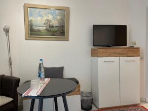 een woonkamer met een tafel en een televisie bij Gästezimmer bei Ingrid in Tübingen