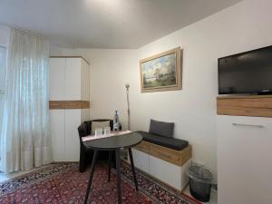 een kleine kamer met een tafel en een televisie bij Gästezimmer bei Ingrid in Tübingen
