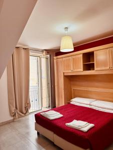 - une chambre avec un lit rouge et une fenêtre dans l'établissement Affacciati sulle Eolie Appartamenti sul Lungomare Patti Marina, à Patti