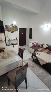 Charming house في أغادير: غرفة معيشة مع أريكة وطاولة وكراسي