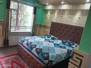 una camera con un letto con una trapunta sopra di Wanderers Homestay -All mountain facing rooms a Kalpa