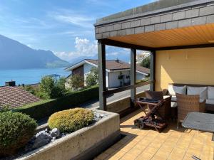 a house with a patio with a view of the water at Swiss Paradise Weggis in Weggis