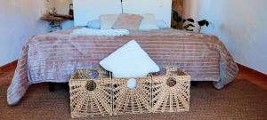 a bedroom with a bed with two wicker tables at Herdade da Maceira in São Luis
