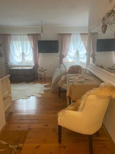 uma sala de estar com uma cama e um sofá e duas janelas em Lomnice nad Popelkou em Lomnice nad Popelkou