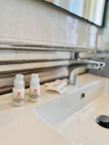 two bottles of medicine sitting on a bathroom sink at Affacciati sulle Eolie Appartamenti sul Lungomare Patti Marina in Patti