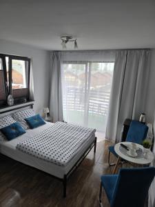 1 dormitorio con cama, mesa y ventana en Sunset Beach, en Sarbinowo