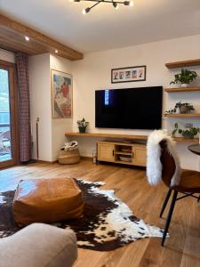 a living room with a flat screen tv and a couch at Cozy bilocale apartment in Breuil-Cervinia