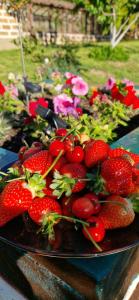 a plate of strawberries on a table with flowers at GreenField GH in Yeghegnadzor