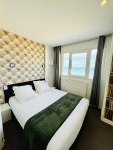 a bedroom with a large bed and a large window at Le Clos Normand in Saint-Aubin-sur-Mer