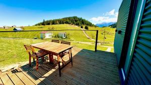 a wooden deck with a wooden table and chairs on it at Sycamore Retreat Fundata in Fundata