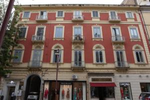 カゼルタにあるRooms & Apartment, A due Passiの通路角赤い建物