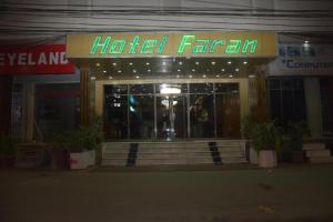 um quarto de hotel com um letreiro de néon em frente em Faran Hotel em Carachi