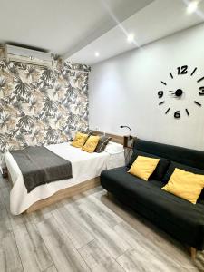 ein Schlafzimmer mit einem Bett und einer Uhr an der Wand in der Unterkunft PRECIOSO ESTUDIO FRENTE AL MAR CON PISCINA in Benalmádena