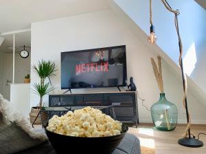 ein Wohnzimmer mit einer Schale Popcorn vor einem TV in der Unterkunft Luna o Mountainview o Pizzaoven in Brunnen