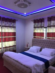 a bedroom with two beds and a purple lighting at Gold Star Hotel Skardu in Skardu