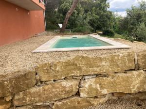 einen Pool in einer Steinmauer neben einem Haus in der Unterkunft La villa Rosa in Bédoin