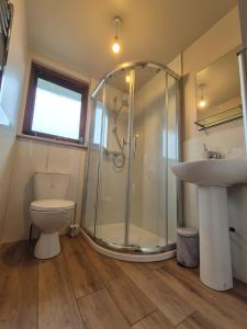 een badkamer met een douche, een toilet en een wastafel bij Hebridean Inn in Broadford