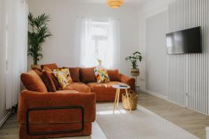 a living room with a brown couch and a tv at Ferienwohnung an der Kirche in Spremberg