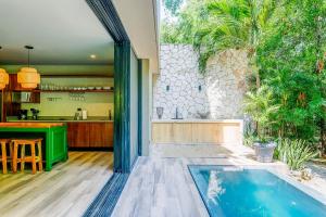 an outdoor kitchen and swimming pool in a house at Luxurious Oasis Jacuzzi with Art Gallery and Pool in Tulum +30 photos