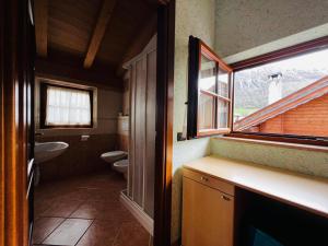 un bagno con un water, un lavandino e una finestra di Residence Gipeto a Livigno Altre 160 foto