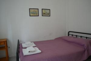 a bedroom with a purple bed with towels on it at Summer Family House with sea view and garden in Kriopigi