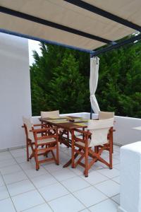 a wooden table and chairs on a patio with a window at Summer Family House with sea view and garden in Kriopigi
