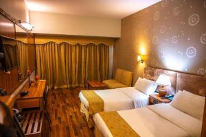 pokój hotelowy z 2 łóżkami i kanapą w obiekcie Faran Hotel w mieście Karaczi
