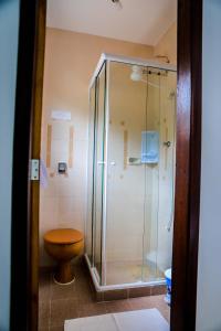 a bathroom with a glass shower with a toilet at Pousada Colibris in Conservatória