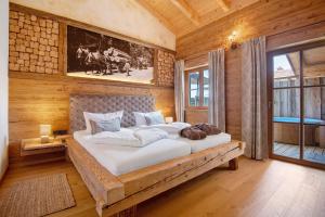 1 dormitorio con 1 cama grande en una habitación de madera en Bergchalet 1, en Freyung