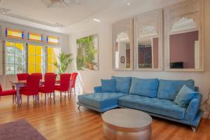 sala de estar con sofá azul, mesa y sillas en Casa Verde Ayamonte en Ayamonte