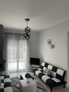 a living room with a couch and a tv at Modern home in Kallithea Halkidikis