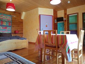 1 dormitorio con mesa, sillas y 1 cama en Noyers du Soleil, Chambre d'hôte avec petit déjeuner à proximité de Gap en La Bâtie-Vieille