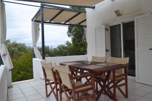 Summer House with sea view and garden في كريوبيجي: فناء على طاولة خشبية وكراسي على شرفة