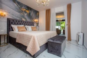a bedroom with a large bed with a painting on the wall at ***Green Dream***- villa in Split in Split