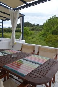 Summer House with sea view and garden في كريوبيجي: طاولة وكراسي على شرفة ذات إطلالة +10 صور