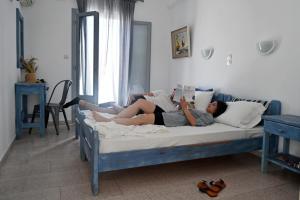 a woman laying on a bed reading a book at Maistrali in Naousa