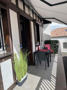 eine Terrasse mit Tisch und Stühlen und einem Sonnenschirm in der Unterkunft Appartement Résidence Saint Jours - Centre ville in Vieux-Boucau-les-Bains