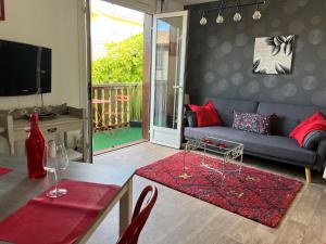 ein Wohnzimmer mit einem blauen Sofa und roten Kissen in der Unterkunft Appartement Résidence Saint Jours - Centre ville in Vieux-Boucau-les-Bains