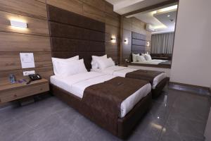 2 camas en una habitación de hotel con paredes de madera en Ibiza Hotel en Jounieh